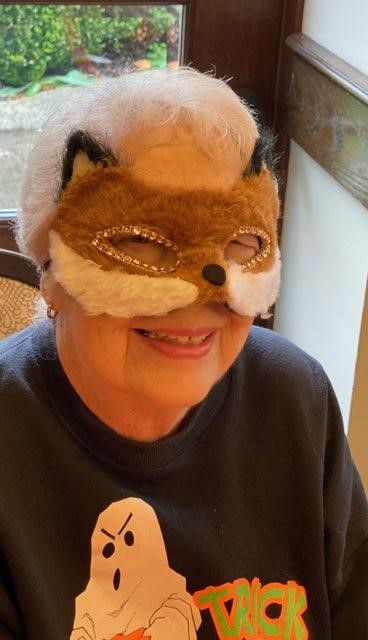 portrait of elderly woman wearing a fox mask