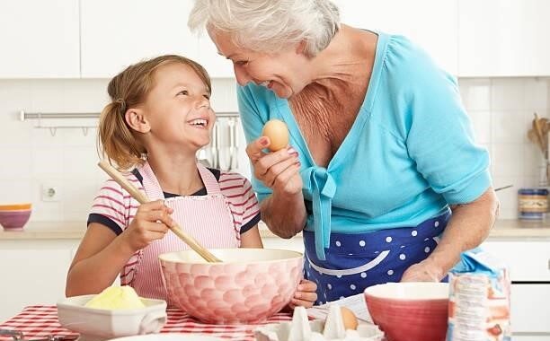 elderly woman and young girl baking together